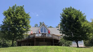 A large house with a wrap-around porch and a covered deck area.
