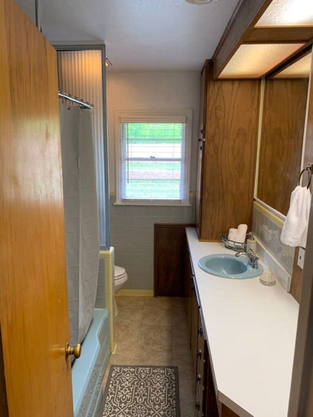 A compact bathroom with a shower, toilet, and sink.