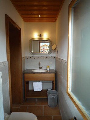 A bathroom with a wooden vanity, a sink, a mirror, and a window. - Apartment 1st floor left - Guesthouse Johanna (Bad Wiessee)