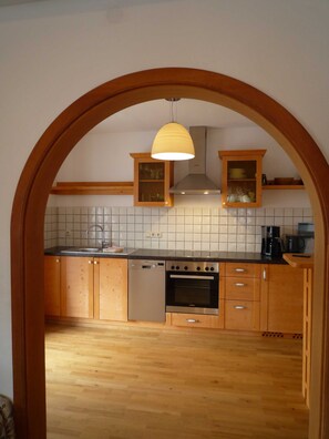 A kitchen with wooden cabinets, a stainless steel stove, and a dishwasher.