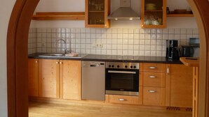 Una cocina con gabinetes de madera, estufa de acero inoxidable y lavavajillas.