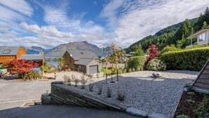 Un quartier résidentiel avec des maisons, une allée gravillonnée et une montagne en arrière-plan.