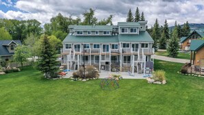 A multi-story building with a green roof, surrounded by a well-maintained lawn and trees. - Spinnaker Point #2 - BEACH FRONT! Come Stay At Our Lake House in Bear Lake, Utah! (Garden City)