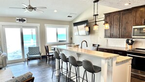 A modern kitchen with a central island, bar stools, and a ceiling fan. - Spinnaker Point #2 - BEACH FRONT! Come Stay At Our Lake House in Bear Lake, Utah! (Garden City)
