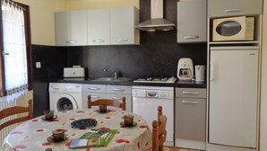 A compact kitchen with a washing machine, microwave, and a coffee maker.