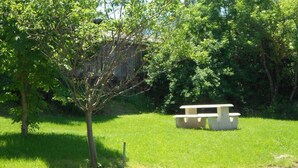 A picnic table in a grassy area with trees in the background.