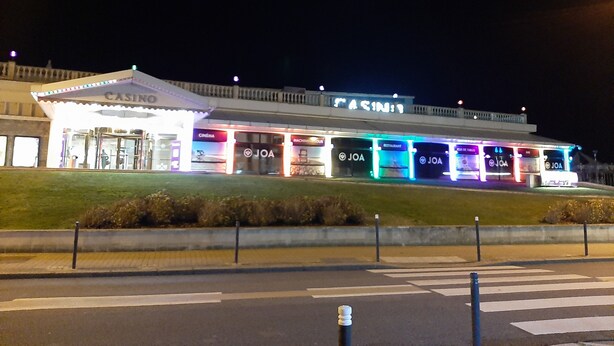 A brightly lit building with a casino, cinema, and multiple restaurants named JOA.