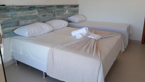Habitación de hotel con cama, un banco y cabecero de diseño rústico.
