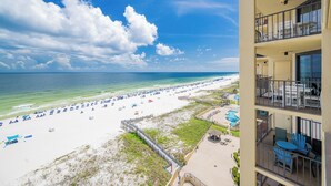 A beach view from a balcony with a pool and outdoor seating area. - 2 Bedroom on the BEACH! Phoenix III (Orange Beach)