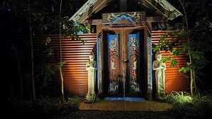L’entrée d’un temple, avec deux statues, une structure en bois et un panneau indiquant qu’il s’agit d’une propriété privée.