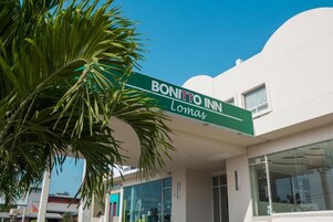 Señal de Bonitto Inn, con un edificio moderno al fondo.