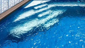 A rooftop pool with a wooden deck, white decorative fence, and potted plants. - Unique House 5Br- Private SPA&POOL - StayInSeville (Sevilla)