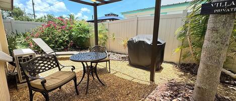 A covered patio area with a table and chairs, a covered grill, and a sign indicating 'Villa Private.'