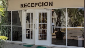 A reception area with a glass door, a sign above reading "RECEPTION", and a "CENSADO" sign on the door.