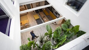 Un interior de varios niveles con un espacio central abierto que cuenta con un sofá, una mesa de madera y un piso con diseño.