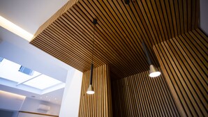 Un interior moderno con techos de listones de madera e iluminación empotrada.