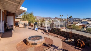 A patio area with a fire pit, outdoor furniture, and a view of a residential neighborhood. - Upgraded lake view (Lake Havasu City)