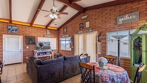 A cozy living room with a sectional sofa, a dining table with a colorful tablecloth, and a green cabinet. - Upgraded lake view (Lake Havasu City)