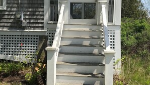 A house with a porch, a set of stairs, and an American flag.