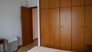 A room with a bed, a radiator, and a wooden wardrobe. - House Near Sea - Andros (Andros)