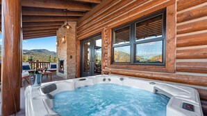 Un jacuzzi en una cabaña de madera con vistas a la montaña.