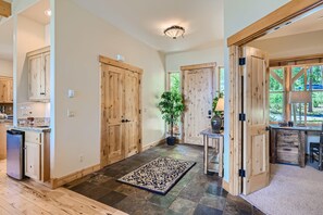 A spacious kitchen with wooden cabinets, a built-in refrigerator, and a large window.