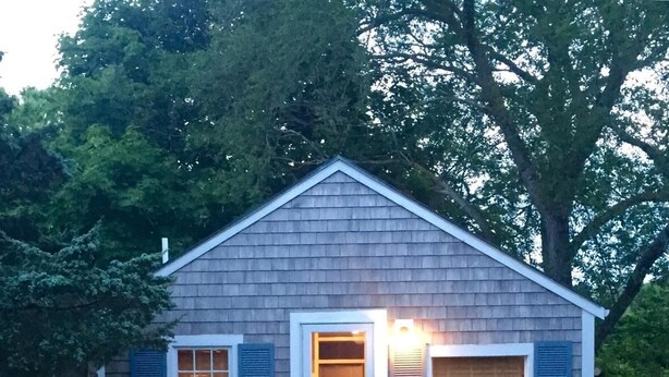 A small, single-story house with a gabled roof and a front door.