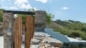 An ancient stone structure with wooden doors and a stone wall.