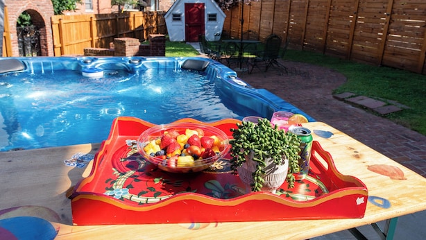 A backyard with a swimming pool, a wooden deck, and a table with a fruit bowl and drinks. - Hot tub, Highlands-Restaurant Row Churchill Downs, Zoo, Bellarmine, Downtown (Louisville)