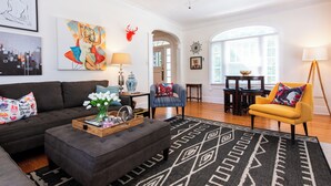 A modern living room with a sofa, ottoman, and armchairs, a coffee table with decorative items, a patterned rug, and a ceiling fan. - Hot tub, Highlands-Restaurant Row Churchill Downs, Zoo, Bellarmine, Downtown (Louisville)