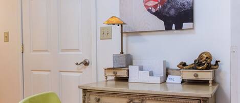 Una habitación con escritorio, una silla y una obra de arte en la pared de un ciervo.