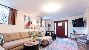 A living room with a sofa, coffee table, and a colorful rug. - Hot tub, Highlands-Restaurant Row Churchill Downs, Zoo, Bellarmine, Downtown (Louisville)