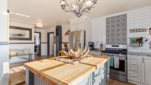 Una cocina moderna con una isla central, electrodomésticos de acero inoxidable y una decoración con astas.