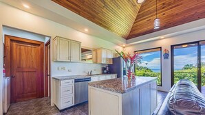 A modern kitchen with granite countertops, wooden cabinets, and a built-in dishwasher. - Don Pedro-Perfect for Couples & Families, Onsite Staff. (Savegre de Aguirre)