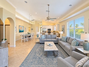 A spacious living room with a sofa, coffee table, and dining area. - High End 4 Bdrm Heated Pool Walk To Gulf Walk To Mercato Walk To The Ritz (Naples)