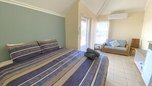 Quarto com cama, sofá, poltrona e escrivaninha.