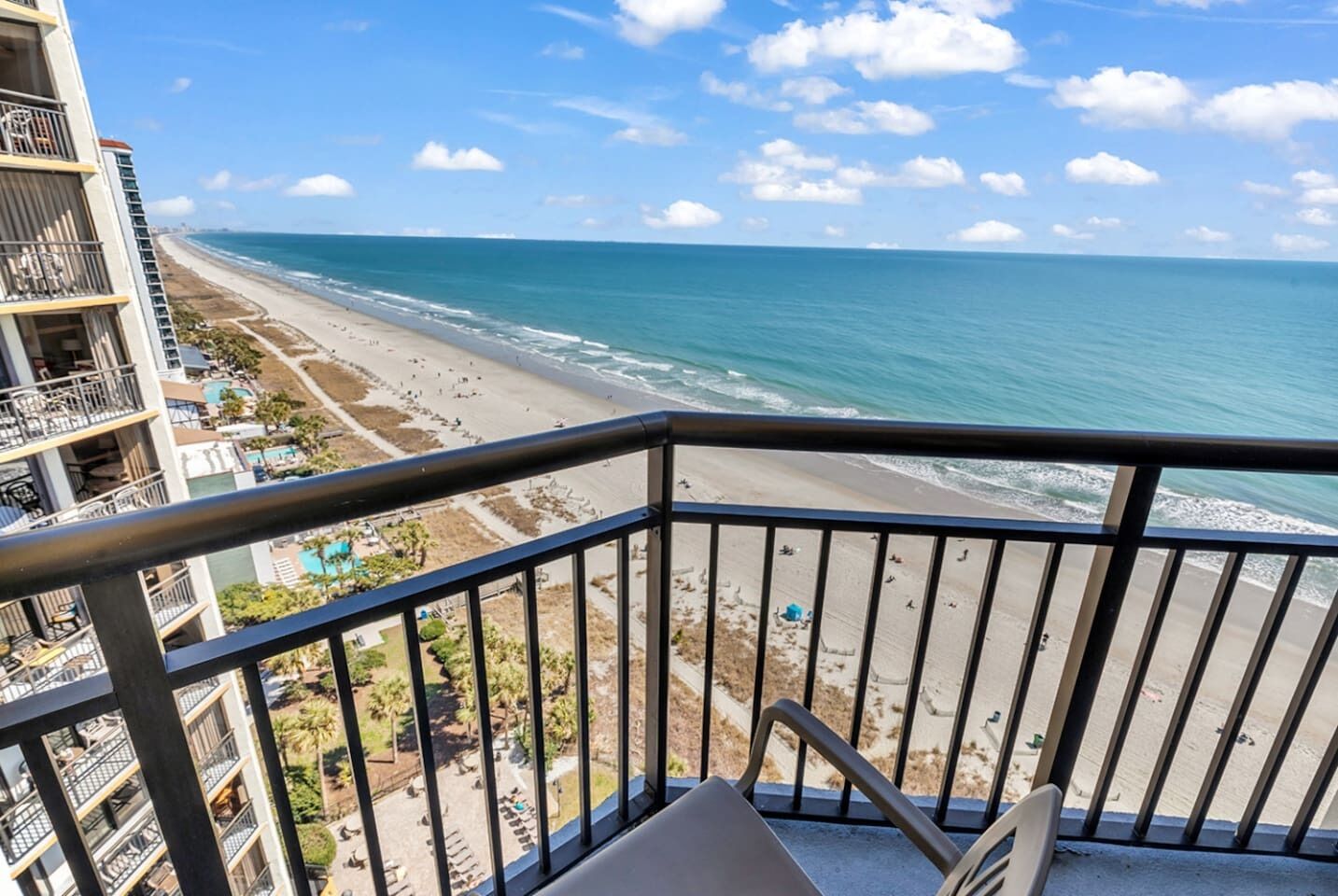 A balcony with a view of a beach and ocean.