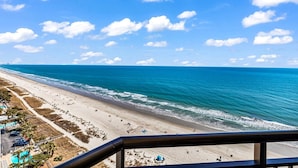 A beach with a clear view of the ocean and a distant shoreline. - Updated Oceanfront 16th floor w/ Amazing Views! (Myrtle Beach)