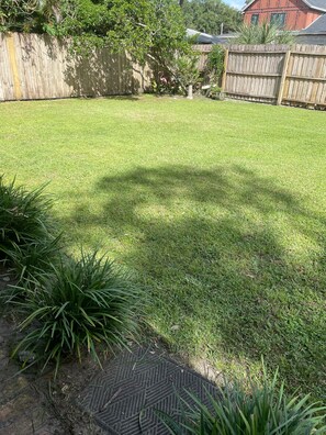Enjoy a serene outdoor space with a beautifully manicured lawn, a wooden fence, and a variety of plants.