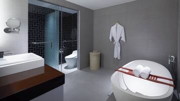 A modern bathroom with a large bathtub, a glass-enclosed shower, and a white sink.