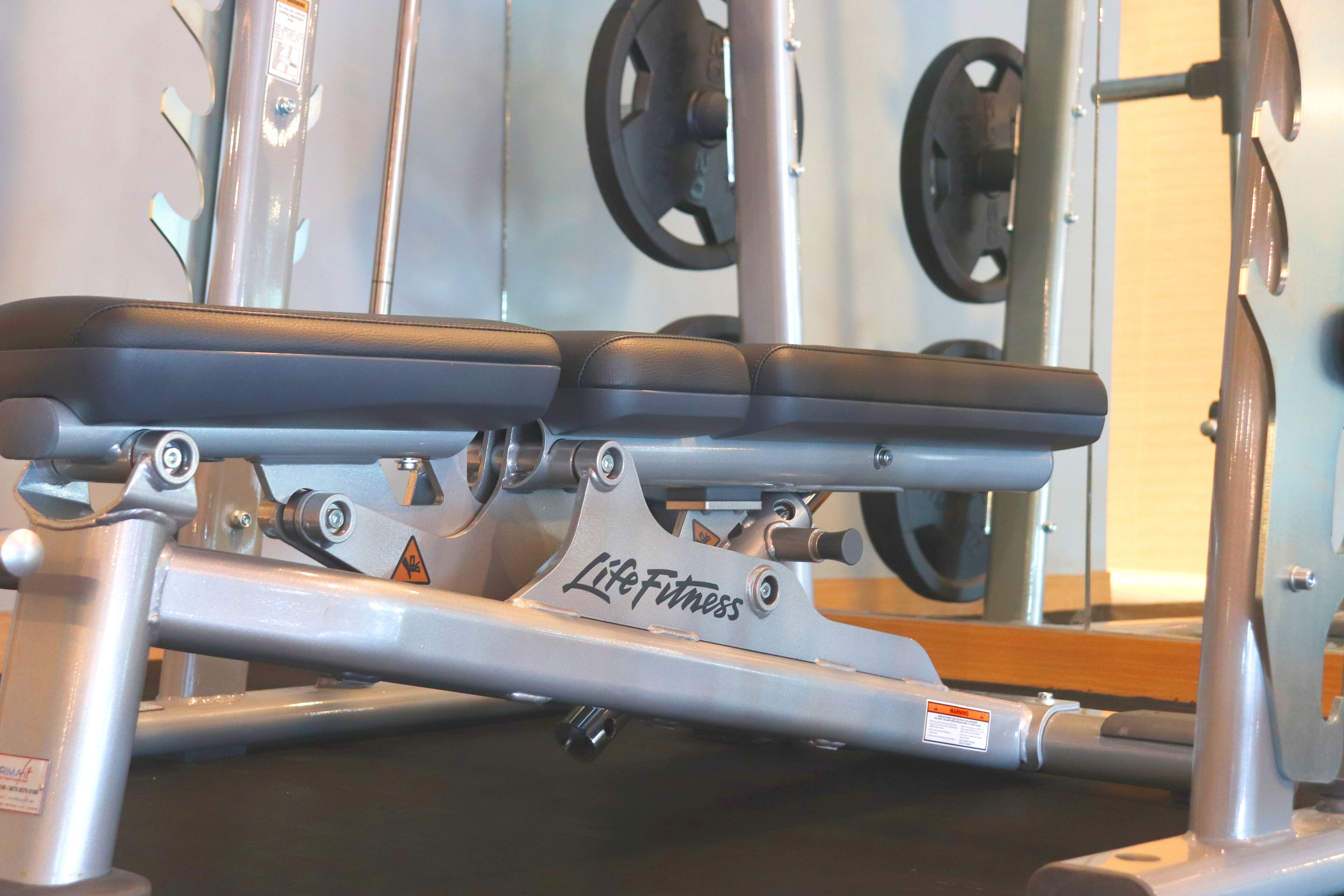 Une salle de sport équipée d’un banc de développé couché et de poids.