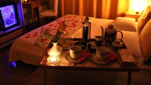 A hotel room with a neatly arranged breakfast tray on the bed, including a teapot, cups, and a small vase with flowers. - CLASSIC ROOM IN VILLA SPA (Mesagne)