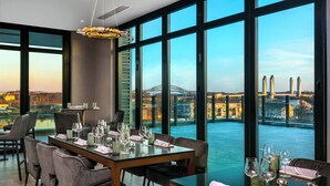 A dining area with a view of a bridge and buildings. - AC Hotel by Marriott Portsmouth (Portsmouth)