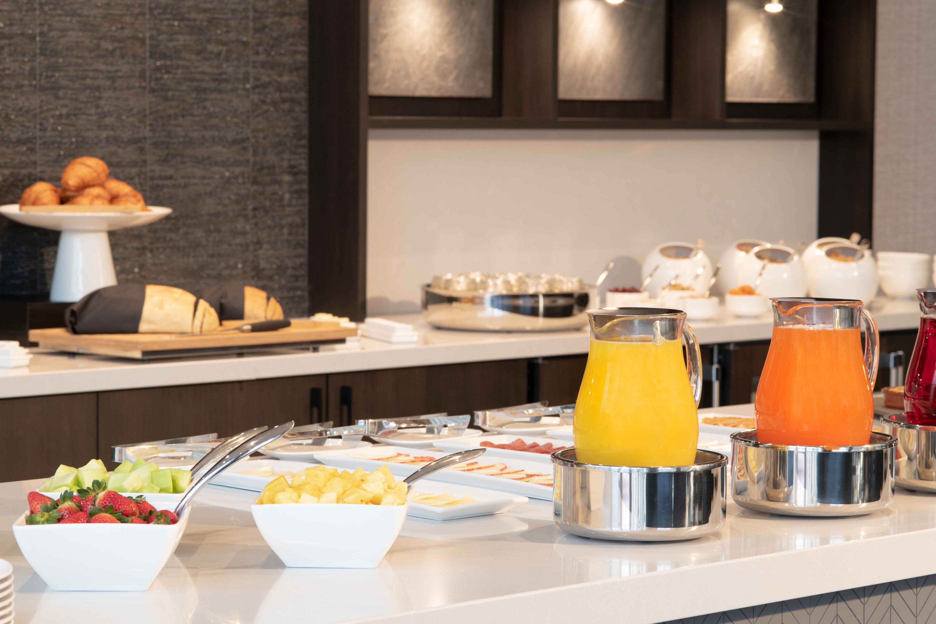 Buffet amb diferents plats per esmorzar, com ara fruita, pastissos i begudes.