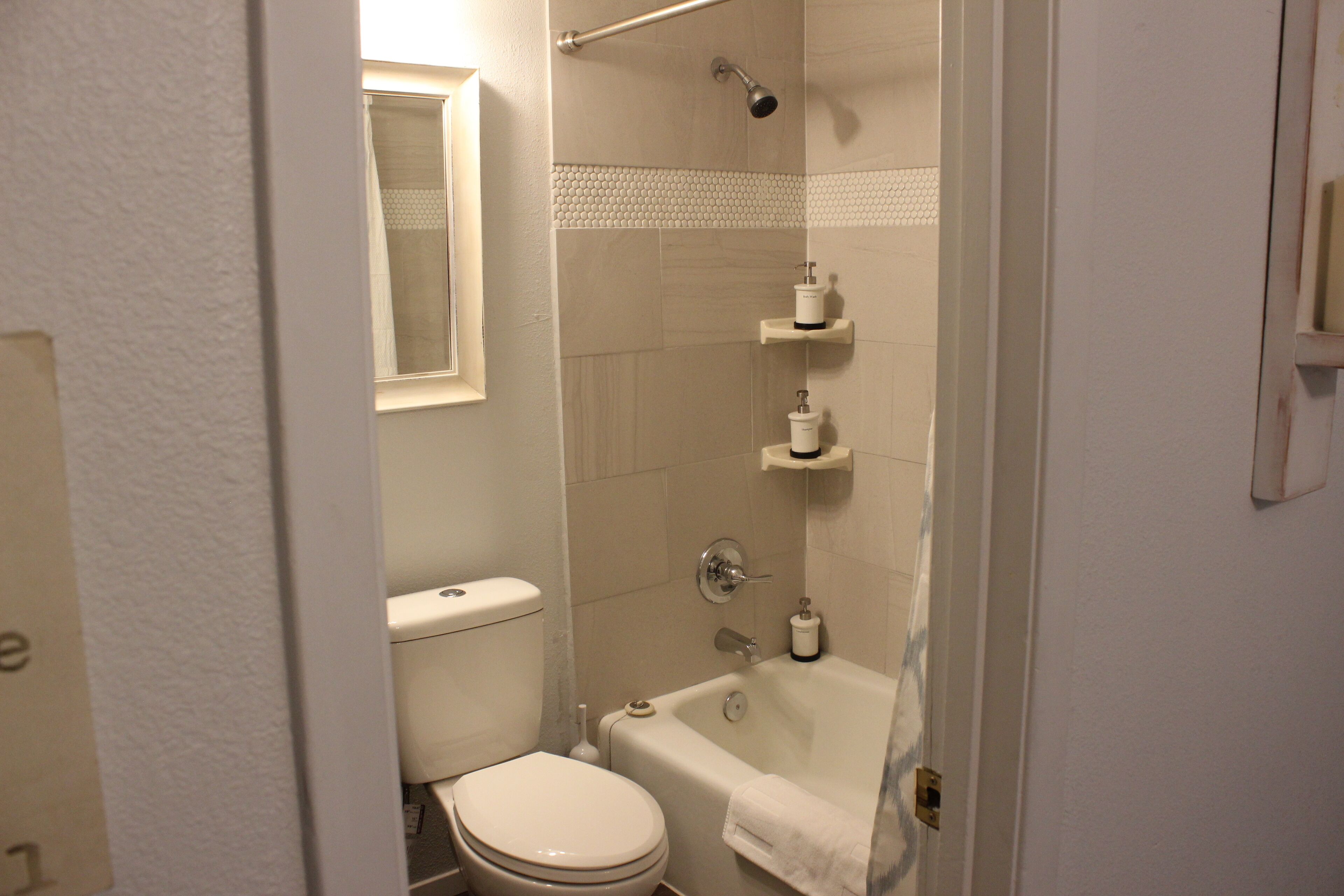 A bathroom with a toilet, a bathtub, and a shower.