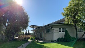 Une maison d’habitation avec le numéro « 1400 » affiché sur le côté, une cour avant et une terrasse en bois.