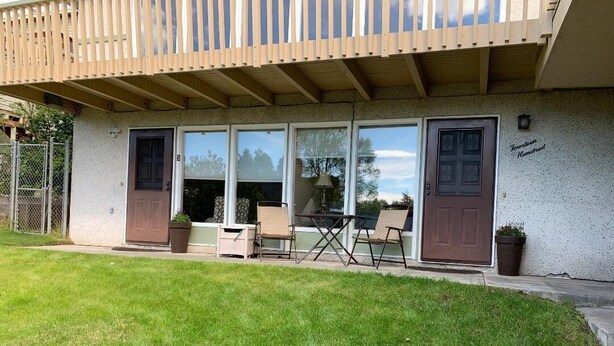 Un immeuble résidentiel doté d’un patio couvert, de portes-fenêtres coulissantes et d’un petit espace extérieur aménagé pour s’asseoir.