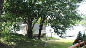 A house with a porch, surrounded by trees and a wooden fence. - Welcome to Heav'nsent (Swanville)