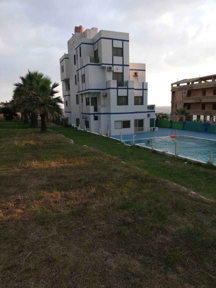 A modern multi-story building with a swimming pool.