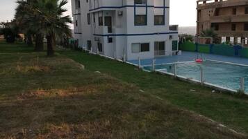 A modern multi-story building with a swimming pool.